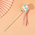 Close-up of cat teaser wand with pastel pom-poms and colorful tassels (82 chars) - Pink Green White Balls With Green Pink White Tassels