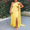 Detailed view of yellow one-shoulder pleated maxi dress with thigh-high slit and cape. - S / Dresses / Yellow