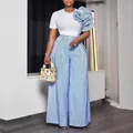 Modella indossa un set pantaloni larghi a righe blu con maxi rouche floreale sulla spalla - Taglia S / Top e Pantaloni / Blu
