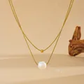 Detaillierte Nahaufnahme einer luxuriösen doppelten Goldkette mit einer Naturperle - D704 Gold Doppelschichtige Perlen Süßwasserperle Halskette / Gold