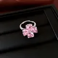 Gedetailleerd zicht van een klaverring met roze hartvormige zirkonia's op zwarte doos. - Klavertjevier Stijl (HR4062) / Zilver-Roze