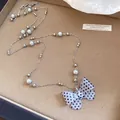 Elegante collana di perle con ciondolo a fiocco a pois bianchi e neri in acrilico da donna. - Taglia S / Bianco