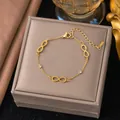 Vista dettagliata di un bracciale infinity placcato oro su una scatola regalo di lusso - Braccialetto Figura 8 (E2098) / Oro