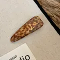 Detailopname van een vintage acryl haarklem met schildpad- en luipaardpatroon - Eendenbekclip-Stijl 1