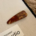 Detailopname van een retro haarclip van acryl met een bruin schildpadpatroon patroon. - Eendenbekclip-Stijl 2