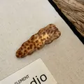 Detailopname van een vintage acryl haarklem met luipaardprint en golvend ontwerp - Eendenbekclip-Stijl 4