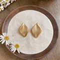 Boucles d'oreilles feuilles dorées mates minimalistes avec fini texturé élégant. - Or