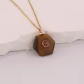 Detailed view of a hexagonal tiger's eye stone pendant with a red gemstone center. - Tiger Eye
