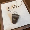 Macro detail of brown leather heart pendant necklace with white and brown beads - Heart / Coffee