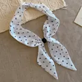 Vista detallada de un pañuelo vintage blanco con lunares negros y cuenta decorativa - Collar-Blanco-Lunares