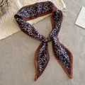 Vista detallada de un pañuelo de algodón con estampado de leopardo vintage y hebilla ámbar. - Collar de Lazo con Estampado de Leopardo Marrón