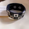 Detailed view of a black leather bracelet featuring silver stars and black pyramid studs. - Star Studs Style / Black