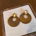 Detailansicht von Retro-Holz-Ohrringen mit polierten goldenen Steckern auf einem Tablett. - Ovaler Metall Holzscheiben Stil / Gold Kaffee (Nr. 1# Silberstift)