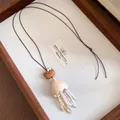 Close-up of retro wooden cat pendant necklace with beaded tassels and leather cord. - Necklace-Coffee-White (Cat Head Tassel)