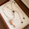 Detailed macro view of handcrafted wooden cat pendant on adjustable braided leather cord. - Necklace-White-Coffee (Sitting Cat)