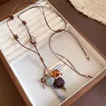 Detailansicht der Vintage-Lederhalskette mit Herz-Schlüssel-Anhänger und Perlen. - Quadratisches Ornament (HN13808) / Silber/Kaffee Halskette (Quadratisch)