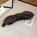 Dettaglio ravvicinato della molletta a banana con fiocco marrone a pois vintage - Morsetto girevole / Marrone Tinta Unita