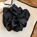 Dettaglio ravvicinato di un grande elastico scrunchie in raso nero a pois bianchi - Elastico per capelli / pois neri