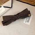 Dettaglio ravvicinato di un fermaglio per capelli vintage a pois marroni con fiocco - Morsetto girevole / Pois Marroni