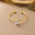 Dettaglio di anello aperto in acciaio dorato con zircone lucido a goccia di pera. - Stile Goccia d'Acqua Strass Bianco (F186) / Oro
