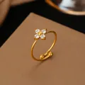 Detail view of 18K gold stainless steel open ring with sparkling flower stones - Flower White Rhinestone Style (F4501) / Gold