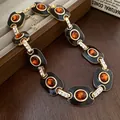 Vintage gold-toned necklace with black enamel inlay and orange oval stones in palace style - Necklace / Brown