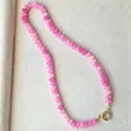 Detailopname van een roze natuurstenen kralenketting met gefacetteerde abacuskralen - 43cm / Roze Steen met Gouden Kralen