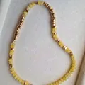 Gedetailleerde weergave van een gele natuurstenen ketting met gouden metalen kralen - 43cm / Gele Steen met Tussenkralen