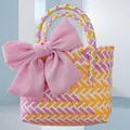 Detailed view of a handmade colorful woven tote bag decorated with a large pink bow accent - Small (With Pink Bow) / Yellow-Pink