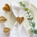 Elegante portatovagliolo in rattan intrecciato a cuore su un tovagliolo bianco di lino - Stile Cuore Intrecciato