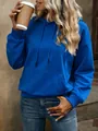 Primer plano de sudadera con capucha azul vibrante oversize para mujer con bolsillo de canguro - Azul Klein