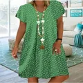Close-up view of a green V-neck summer dress featuring a delicate white heart pattern. - S / Dresses / Green