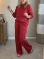 Model wearing a festive red sparkling two-piece loungewear sweatshirt and wide-leg pant set. - Red / S
