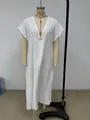 Detailed view of white cotton linen maxi dress featuring delicate lace trim on the V-neckline - S / Dresses / White