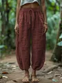 Detail of loose brick red lantern pants with elastic drawstring waist and linen texture. - S / Bottoms / Chestnut