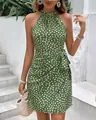 Dettaglio di un abito verde allacciato al collo con pois bianchi e fiocco in vita - Taglia S / Vestiti / Verde brillante