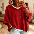 Close-up of a women's oversized red knitted hooded sweater with drawstring details. - Red