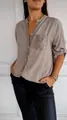 Close-up detail of silver sequins on the pocket and placket of a taupe blouse - Khaki