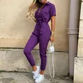 Vue d'ensemble d'une combinaison utilitaire violette à manches courtes avec revers et ceinture. - S / Combinaisons / Violet