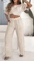 Detail shot of women's beige linen set with floral embroidery and high-waisted pants - Apricot