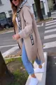 Stijlvolle lifestyle-weergave van een lange beige fleecejas met capuchon voor dames met lint - Tops / S / Abrikoos