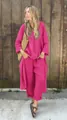Vue extérieure d'une femme portant un ensemble deux pièces en coton et lin fuchsia et accessoires - Rose rouge