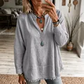 Gros plan sur le détail du bas effiloché d'une blouse à manches longues en couleur bleu clair. - Gris