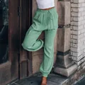 Detailopname van de stijlvolle saliegroene harembroek van rayon met trekkoord in de taille. - S / Bottoms / Lichtgroen