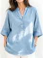 Close-up detail of light blue linen blouse with V-neckline and wood-style buttons - S / Tops / Light Blue