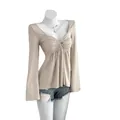 Haut élégant à manches longues beige avec devant torsadé et col en V sur mannequin - XS / Hauts / Abricot