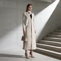 Elegante trench lungo beige con collo drappeggiato per un look da ufficio raffinato. - Taglia S / Top / Albicocca