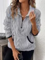 Détail de la texture en peluche et de la demi-fermeture éclair sur ce sweat-shirt gris. - Gris clair