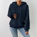 Nahaufnahme eines dicken dunkelblauen Jacquard-Kapuzenpullovers mit Zopfmustertextur. - Marineblau