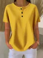 Close-up of yellow waffle-knit Henley shirt featuring front buttons and soft textured fabric. - Yellow